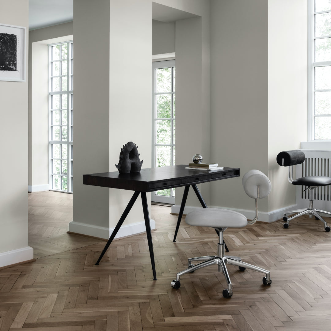 Modern home office space with a dark wood desk - JFK Home Desk - and white chairs.