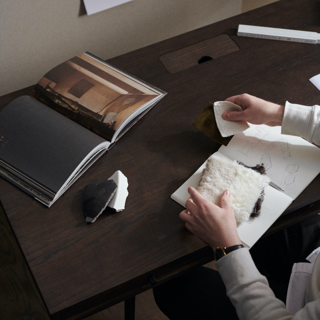 closeup of NORR11 JFK Home Desk in use by a designer with fabric swatches
