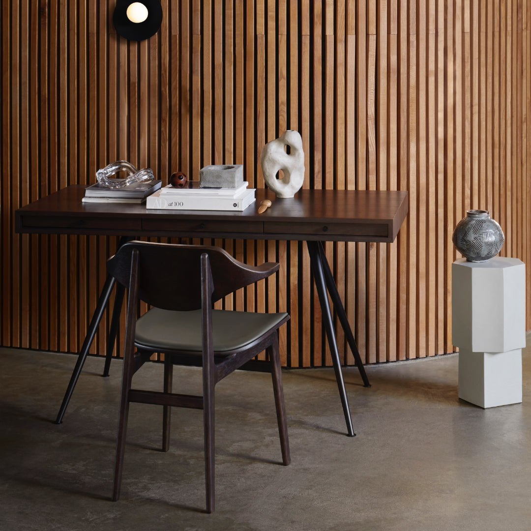 Wooden JFK Home Desk with chair against a wooden paneled wall