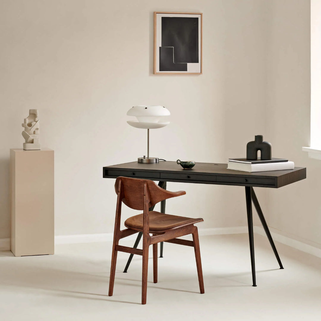 JFK Office Desk - Modern office setup with a desk, chair, and decor items in a minimalistic room.