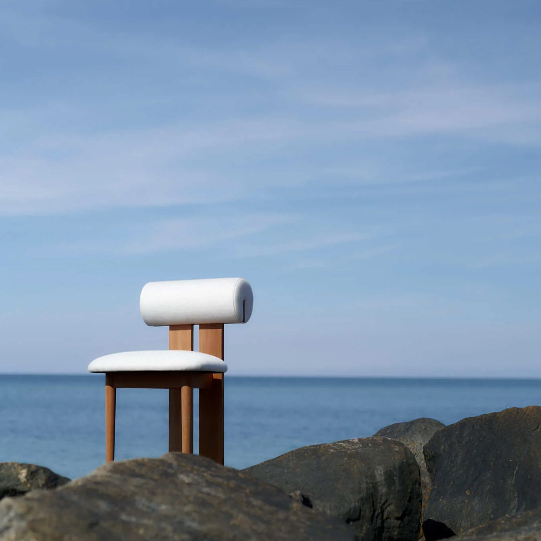 NORR11 Hippo Outdoor Chair on rocks with ocean and sky in the background