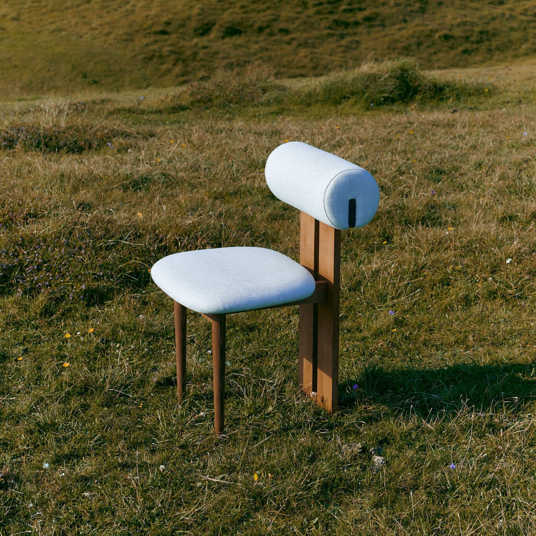 NORR11 Hippo Outdoor Chair with cylindrical backrest in a grassy field