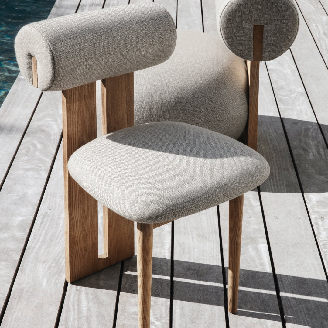NORR11 Hippo Outdoor Chair - Modern chair with wooden legs and gray cushioned seat and backrest on a wooden deck.